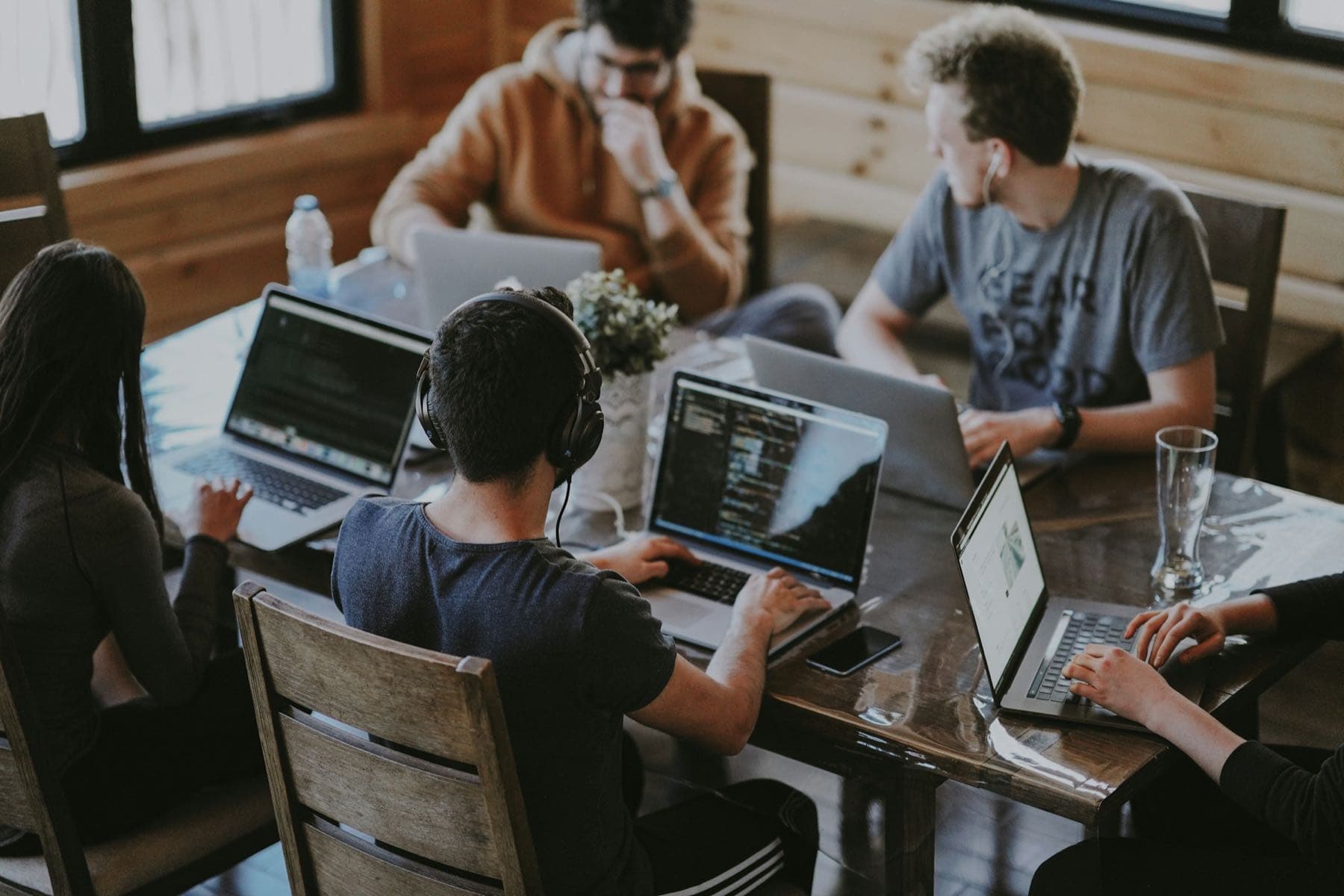 Hands on laptops around a wooden table